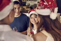 Fröhliche junge asiatische Freunde feiern gemeinsam Weihnachten im Café — Stockfoto