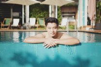 Young attractive asian man relaxing in swimming pool — Stock Photo