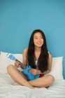 Китайська жінка, що грають на гавайська гітара в домашніх умовах — стокове фото