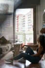 Vista lateral de Sexy mujer china descansando en casa - foto de stock
