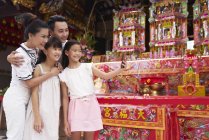 Happy asian family taking selfie together in traditional Singaporean shrine — Stock Photo