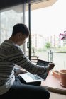Junge erwachsene asiatische Mann mit Laptop zu Hause — Stockfoto