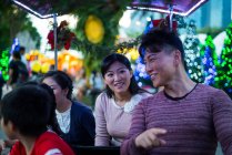 Happy asian family spending time together in amusement park at christmas — Stock Photo
