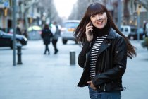 Young attractive asian woman in city using smartphone — Stock Photo