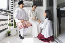 Felice famiglia asiatica che celebra hari raya a casa — Foto stock