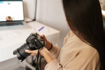 Довге волосся жінка перевіряє свій фотоапарат — стокове фото