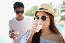 Junge asiatische Paar trinkt Cocktails in Café zusammen — Stockfoto