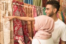 Jovem casal muçulmano comprando tecidos em uma loja — Fotografia de Stock