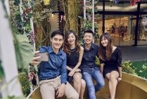 Happy young asian friends taking selfie with christmas decorations — Stock Photo