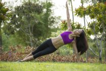 Una giovane donna asiatica sta facendo yoga nel parco di Marina Bay
. — Foto stock