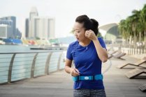 Joven deportivo asiático mujer con auriculares - foto de stock