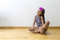 Маленькая симпатичная девочка в короне, сидящая на полу — стоковое фото