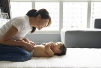 Mother changing diapers for her adorable baby boy — Stock Photo