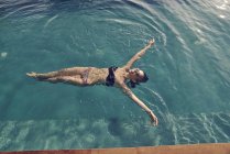 Красивая молодая женщина плавает спиной в бассейне — стоковое фото