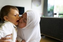 Mãe em Hijab brincando com seu filho na sala de estar — Fotografia de Stock