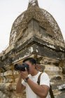 Joven tomando fotos en la pagoda Shwesandaw, Bagan, Myanmar - foto de stock