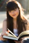Giovane donna eurasiatica lettura libro, messa a fuoco selettiva — Foto stock