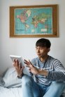 Jeune homme asiatique adulte en utilisant une tablette numérique à la maison — Photo de stock