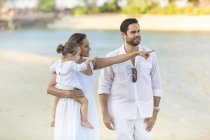 Happy young family spending time together on beach — Stock Photo