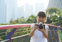 Jovencita divirtiéndose con una cámara en Gardens by the Bay, Singapur - foto de stock