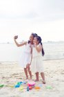 RELEASES Two little sisters spending time together on beach and taking selfie — Stock Photo
