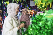 Deux femmes musulmanes faisant leurs courses pour des décorations au hari raya
. — Photo de stock