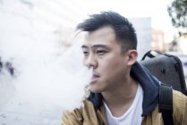 Joven asiático músico macho con violín y vapor en ciudad - foto de stock