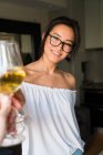 Mulher chinesa brinde com vinho branco sorrindo com copos dentro de casa — Fotografia de Stock