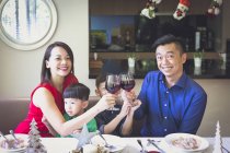 Une famille singapourienne de quatre personnes profite d'un dîner festif dans leur belle maison pendant les vacances de Noël . — Photo de stock
