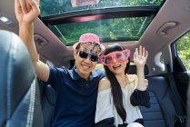 Paar amüsiert sich auf dem Rücksitz eines Autos — Stockfoto