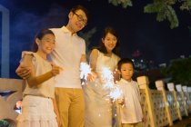 RELEASES young asian family together with sparklers at Chinese New Year — Stock Photo