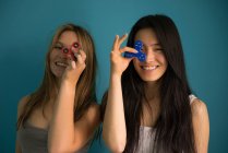Chinese woman playing spinner with a friend in a blue background. — Stock Photo
