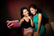 Good girl friends taking selfie in night club — Stock Photo