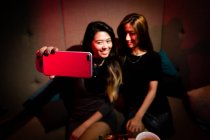Good girlfriends taking selfie in night club — Stock Photo