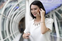 Молода приваблива азіатська жінка використовує смартфон — стокове фото