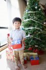 Счастливый мальчик празднует Рождество с подарком дома — стоковое фото