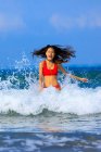 Zwei junge asiatische Frauen haben eine großartige Zeit in den Wellen des Ozeans. — Stockfoto