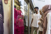 Группа счастливых друзей-мусульман, которые ходят по магазинам и смотрят в витрину магазина — стоковое фото