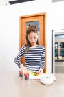 Jovem asiático mulher corte morangos no cozinha — Fotografia de Stock