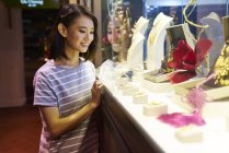 Молодая азиатская женщина смотрит на ювелирные изделия в магазине — стоковое фото