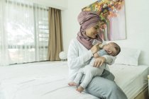 Madre che alimenta il suo bambino a casa moderna — Foto stock