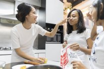 Happy asian family celebrating hari raya at home and cooking at kitchen — Stock Photo
