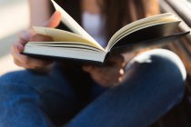 Cropped image of young woman reading book, closeup — Stock Photo