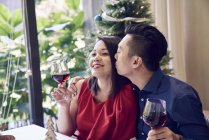 Happy asian couple with wine celebrating christmas — Stock Photo