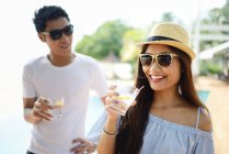 Young attractive asian couple having drink — Stock Photo