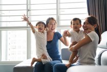 RELEASES Young mothers bonding with their children in the living room — Stock Photo