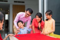 Счастливая азиатская семья рисует иероглифы каллиграфии — стоковое фото