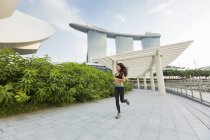Une jeune femme asiatique fait du jogging dans la baie de la marina de Singapour
. — Photo de stock