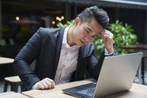 Молодий азіатський успішний бізнесмен використовує ноутбук — стокове фото