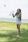 Junge kleine süße asiatische Mädchen mit Badminton-Rakete im Park — Stockfoto